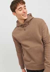 Hoodie marrone realizzato in tessuto morbido, con cappuccio con cordino, tasca a marsupio e polsini e orlo a costine. Texture liscia con design semplice.