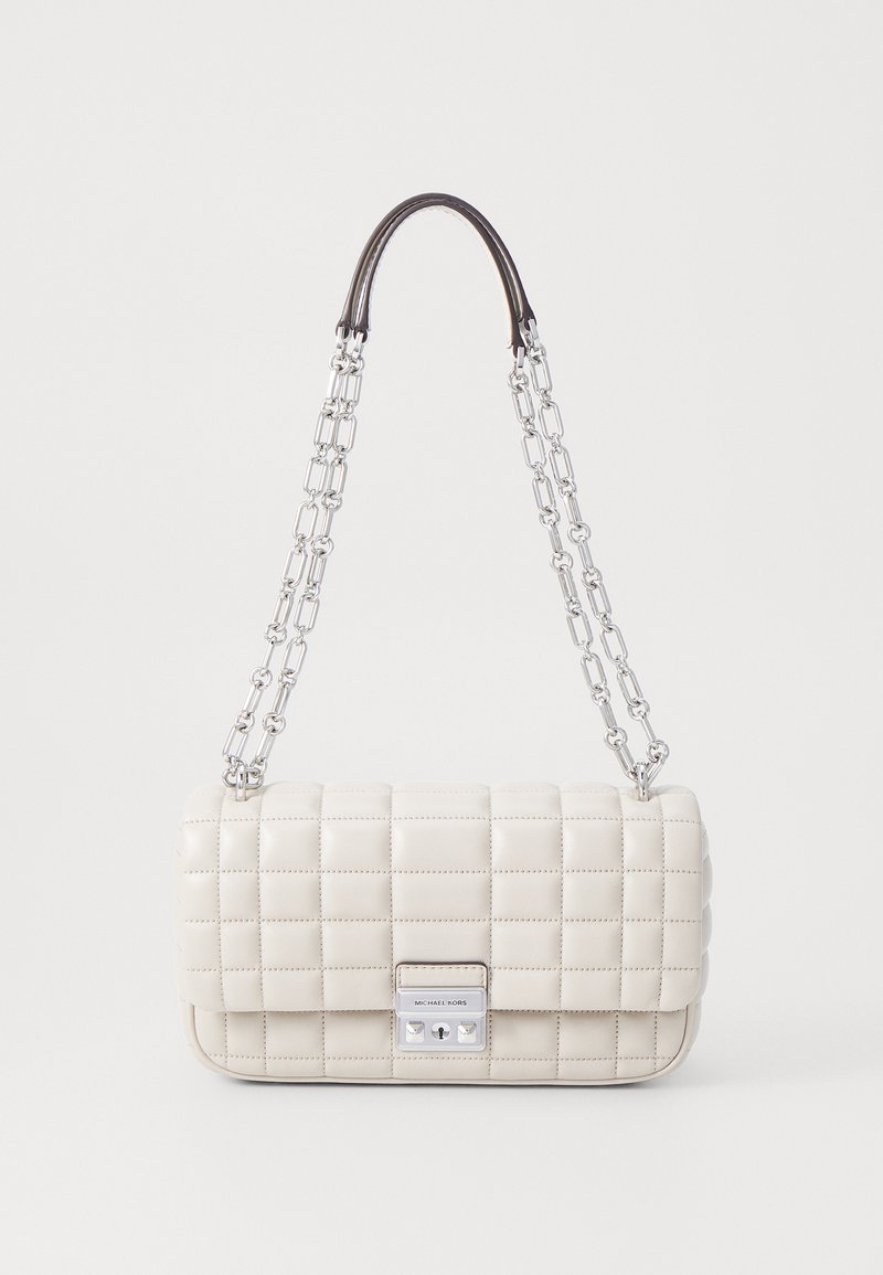 Borsa a tracolla crema trapuntata con una catena d'argento e un manico superiore marrone scuro. Caratterizzata da una chiusura metallica e una forma rettangolare con una texture liscia.