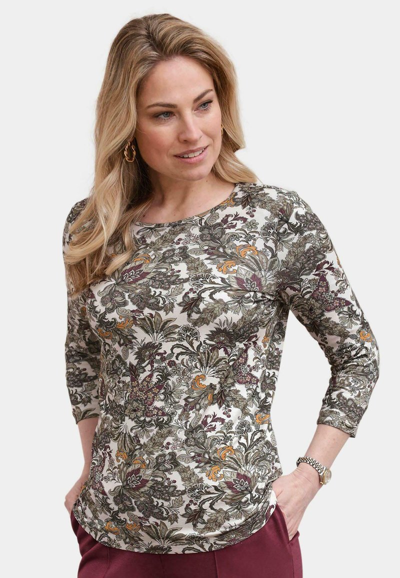Blumenmuster-Oberteil mit langen Ärmeln in Creme, das grüne, lila und orangefarbene Muster aufweist. Weicher Stoff mit rundem Kragen und Dreiviertelärmeln.