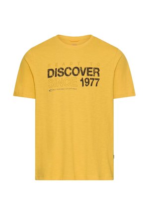 Geel T-shirt met korte mouwen en zwarte tekst met omlijning: "Klaar om te ontdekken sinds 1977, gemaakt voor dagelijkse avonturen."