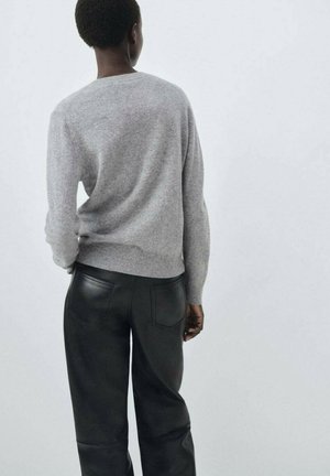 Gray wool sweater with a rounded neckline, paired with black leather trousers. The textures are soft and smooth, showcasing subtle details.
