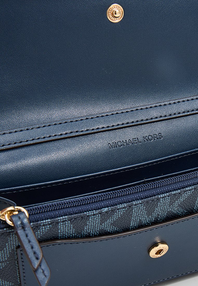 Portafoglio in pelle blu navy con hardware dorato, dotato di scomparto con zip, fodera a motivo geometrico e marchio impresso "Michael Kors".