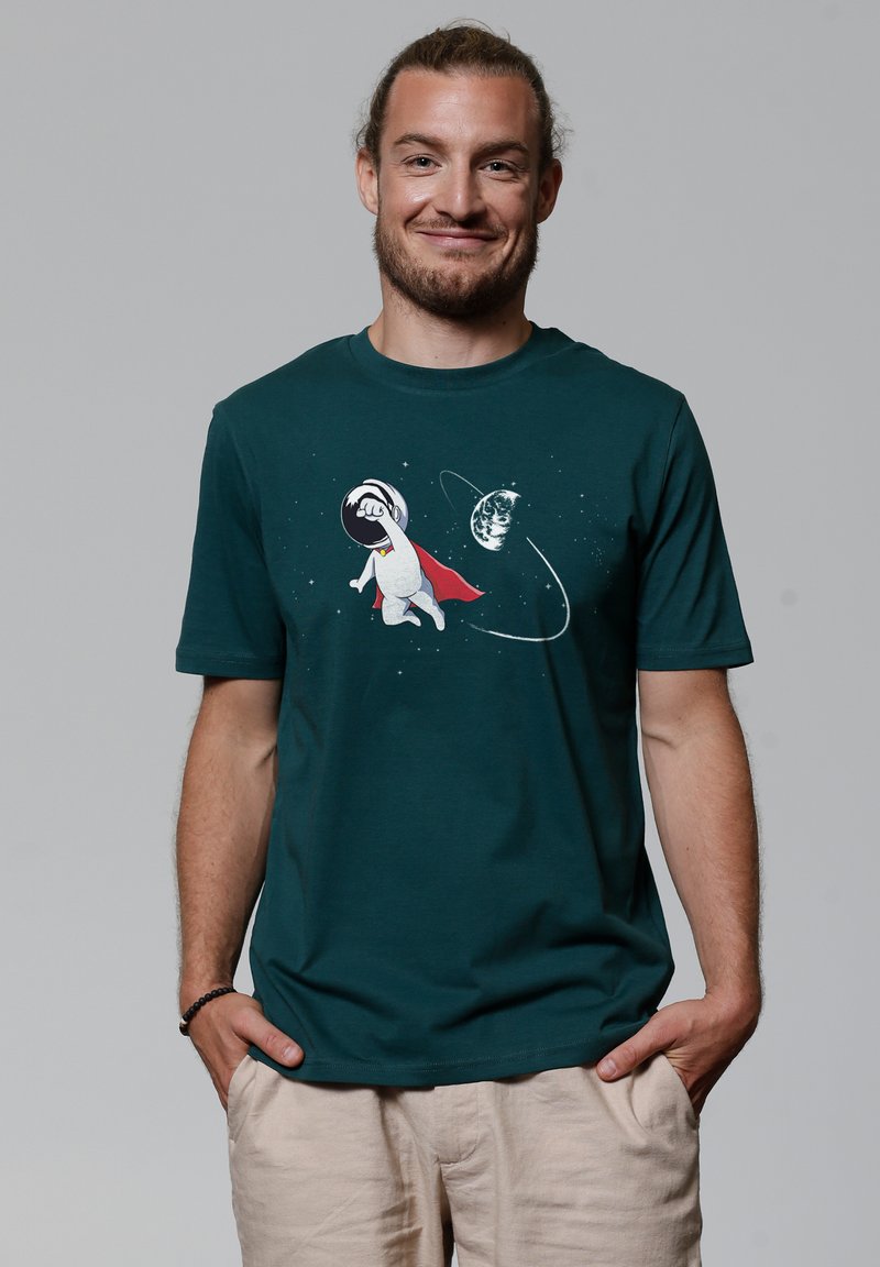 Donkerblauwe katoenen t-shirt met een afbeelding van een cartoonfiguur in een ruimtepak en een rode cape, met planeten en sterren in het wit geïllustreerd.