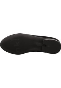 Schwarze Schuhsohle mit einer strukturierten Oberfläche, horizontalen Linien und einem kreisförmigen Abschnitt an der Ferse. Markenlogo auf der Sohle sichtbar.