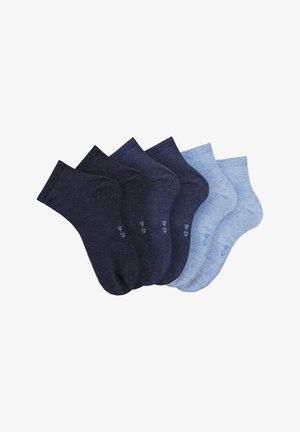 Five pairs of cotton socks in dark navy, medium navy, light blue, and heather blue shades, with ribbed cuffs and size labels on the soles.