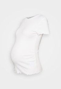 Valkoinen äitiys t-paita, joka on valmistettu venyvästä kankaasta. Siinä on pyöreä pääntie, lyhyet hihat ja hieman aallotettu helma, joka sopii vatsan päälle.