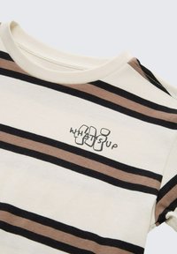 Streep T-shirt in ivoor, met horizontale zwarte en bruine strepen. Inclusief grafische tekst "WHATS UP" in zwart. Zachte katoenkwaliteit.