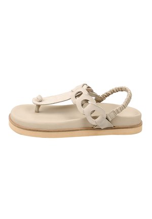 Beige platte sandaal met dempende zool, lusvormige teensluiting, decoratieve ronde uitsnijdingen aan de zijkant en elastische hielband.