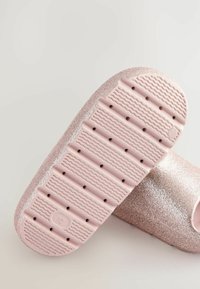 Glitterende roségouden zool met een textuur van golfpatronen en gaten voor grip. Gladde bovenkant met een open teen ontwerp. Lichtgewicht materiaal.
