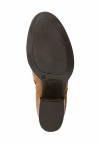 Suola di scarpa in suede marrone con fondo in gomma nera testurizzata. Presenta una forma arrotondata e un lieve tacco, con un logo vicino al tacco.