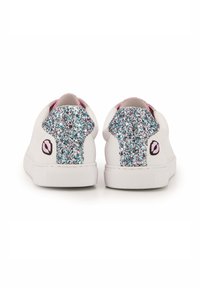 Baskets blanches avec une doublure intérieure rose, présentant un onglet de talon multicolore pailleté et un petit design de logo sur le côté.