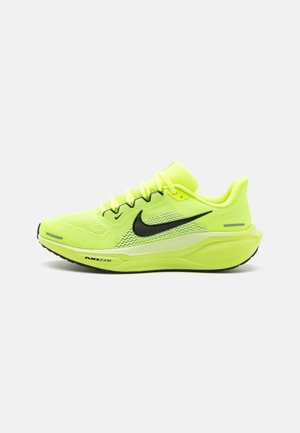 Neonowo żółty but do biegania Nike z czarnym logo w kształcie łyżwy, oddychającą siateczkową cholewką, amortyzowaną podeszwą i etykietą "Air Zoom" na podeszwie środkowej.