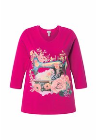 Fuksia t-paita V-kauluksella ja kolmennesateen hihat, jossa on värikäs ompelukonekuvio kukkaelementtien ympäröimänä.
