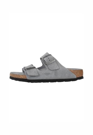 Sandalo in suede grigio con due cinturini regolabili e fibbie in metallo. Plantare in sughero per comfort e suola in gomma nera per trazione.