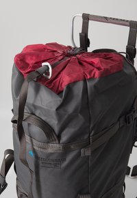 Zaino con corpo grigio testurizzato, chiusura superiore rossa con cordoncino e spallacci neri; include un logo contrassegnato di lato.