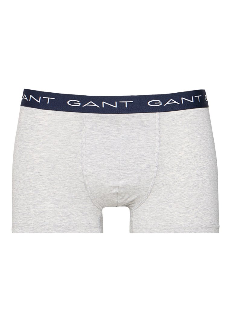 Grå bomullboxershorts med en marinblå midja som har det upprepade "GANT"-logot. Slät textur och medellång passform för komfort.