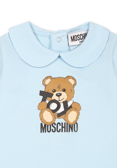 Lichtblauwe katoenen rompertje met een berenillustratie en de tekst "TOY". Rond de kraag, drukknoopsluiting aan de achterkant en het logo "MOSCHINO".