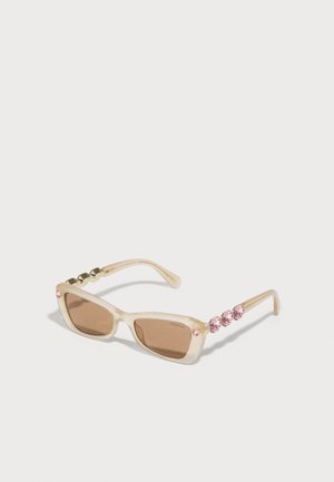 Ochelari de soare dreptunghiulari bej cu lentile de culoare maro. Temele decorate cu cuiere aurii și strassuri roz. Design elegant și modern.