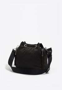 Čierna nylonová taška s měkkou textúrou, s dvoma uchami, odnímateľným ramenným popruhom a bočnou vreckom so zipsom.