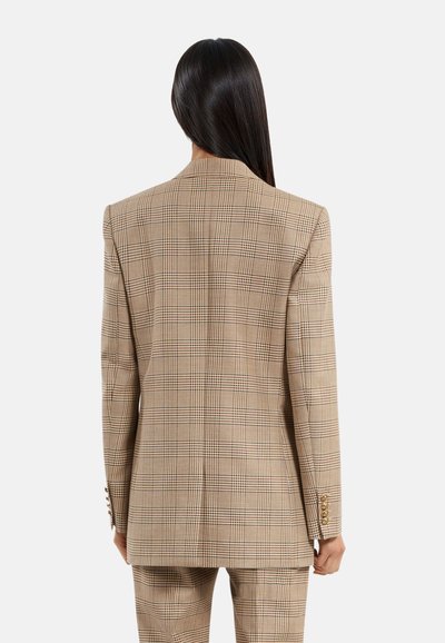 Blazer de cuadros beige con una forma estructurada, solapa de muesca y acentos de botones dorados en las mangas. Textura suave con un ajuste a medida.