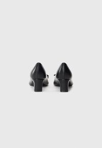 Black leather high-heeled shoes with a tapered design and rounded toe. Features a low block heel and smooth texture.