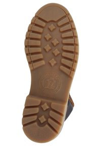 Sola de sapato de borracha castanha com padrões de fundo profundos, logótipo circular no centro e um acabamento texturizado para uma melhor aderência.