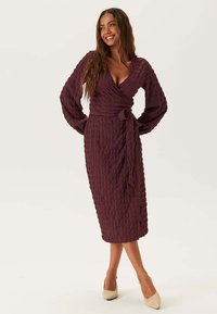 Wijnkleurige, gestructureerde midi-jurk met een wikkeldesign, lange mouwen en een strikdetail in de taille. Glad, lichtgewicht stof met een ruitpatroon.