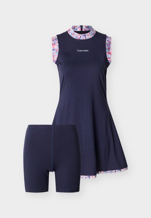 Vestido sin mangas azul marino con ribete de patrón multicolor y pantalones cortos ajustados azul marino a juego, logo de Calvin Klein en el pecho.