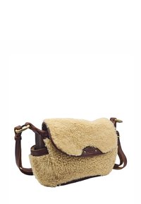 Sac crossbody en shearling beige avec une base en cuir marron. Il dispose d'un rabat pliable et d'une bandoulière réglable, mettant en valeur un matériau texturé et du matériel en laiton.