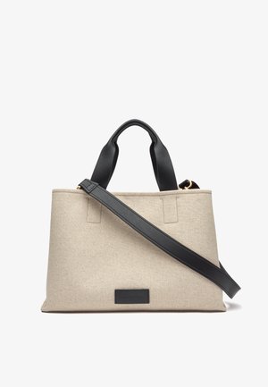 Beige stoffen shopper met zwarte leren hengsels. Heeft een gestructureerde vorm met een gladde textuur en een klein zwart label aan de voorkant.