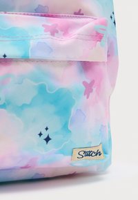 Παιδικό σακίδιο πλάτης σε παστέλ χρώματα, κατασκευασμένο από ύφασμα με μοτίβο υδατοχρώματος σε αποχρώσεις μπλε, ροζ και μωβ, με ραμμένη ετικέτα λογότυπου.