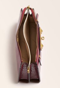 Bolso de mano de cocodrilo texturizado en color burdeos con una cremallera y herrajes dorados; dos compartimentos internos; forro suave; acentos triangulares.