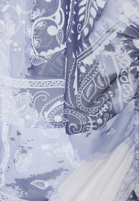Lightweight fabric featuring a blue and white paisley pattern, with textured layers and gathered accents for added detail.