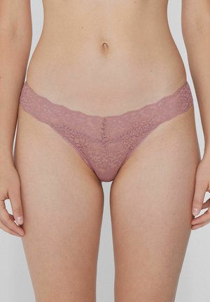 Rosa Spitzenstring mit gewellten Kanten, floralen Mustern und transparenter Textur, entworfen für Komfort, mit minimaler Bedeckung und elastischen Bändern.
