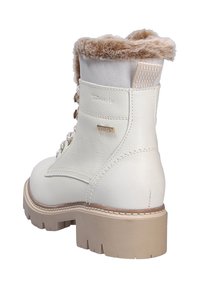 Botas de tobillo de imitación de cuero blancas con un puño de piel sintética beige, cordones en la parte delantera y una suela gruesa de color marrón claro. Presenta la marca "Tamaris".