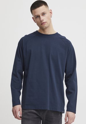 Marineblaues Langarm-T-Shirt aus Baumwolle. Mit Rundhalsausschnitt, Raglanärmeln und lockerer Passform. Minimalistisches Design ohne sichtbare Muster.