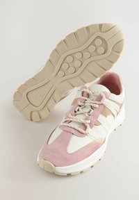 Lättviktig sportskor med övre i rosa mocka och vit textil, med beige accenter och texturerad gummisula. Snören med förstärkt design.