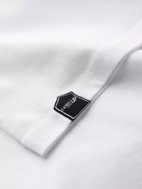 Weißes Baumwoll-T-Shirt mit einem schwarzen sechseckigen Etikett, das "LEVEL UP" liest, mit kontrastierendem Stich und einer glatten Textur.