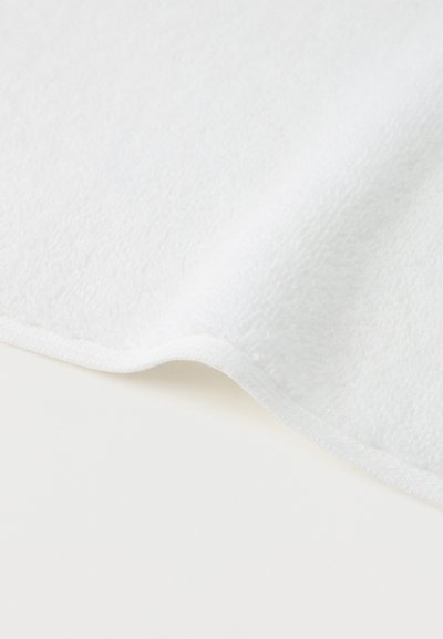 Soft white fabric with a slightly raised, textured surface and stitched edges, laid flat with a gentle fold.