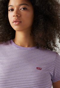 Purple striped T-shirt made of soft cotton, featuring a crew neck and a small red Levi's logo on the chest.