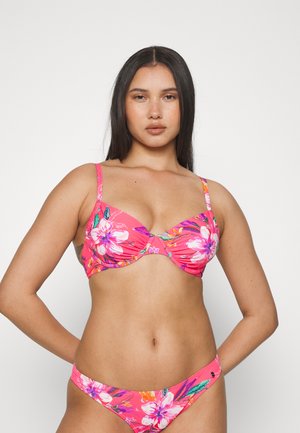 Różowy kostium bikini w kwiaty z marszczonym topem na drutach, z regulowanymi ramiączkami oraz pasującymi, niskimi majtkami. Żywe wzory kwiatowe i tropikalne kolory.