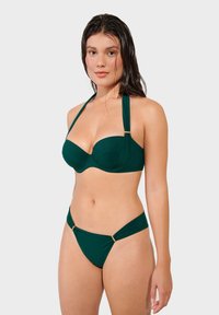 Green bikini set with a padded bandeau top featuring gold accent hardware and adjustable straps, paired with low-cut hipster briefs.