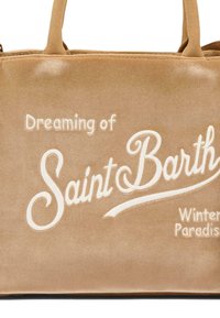 Sac en velours tan avec un texte brodé blanc : "Rêver du paradis hivernal de Saint Barth." Dispose de deux poignées robustes.
