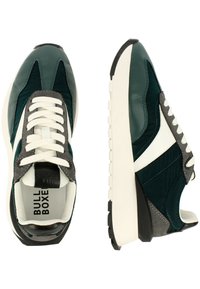 Gröna och svarta sneakers med vita accenter, som har en blandning av släta och texturerade material, rund tå och tjock vit sula.