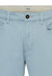 Jasnoniebieskie dżinsy z mieszanki bawełny o regularnym kroju, z zapięciem na guzik, dwiema przednimi kieszeniami i subtelnymi detalami w stępnieniu.