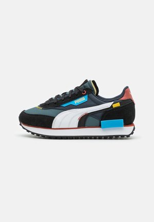 Ciemnozielone i czarne buty sportowe Puma z białym paskiem, niebieską etykietą Puma, czerwoną zakładką na pięcie i niebieskim prostokątnym detalem na podeszwie.