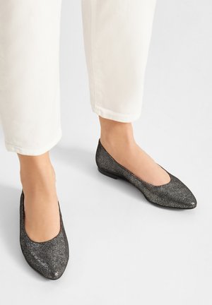 Czarne baleriny z brokatem, z zaostrzonym noskiem, niskim obcasem i gładką fakturą. Połączone z białymi, krótkimi spodniami.