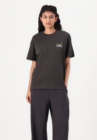 T-shirt in cotone grigio scuro con maniche corte, caratterizzato da una piccola grafica colorata nell'area del petto sinistro. Vestibilità comoda.