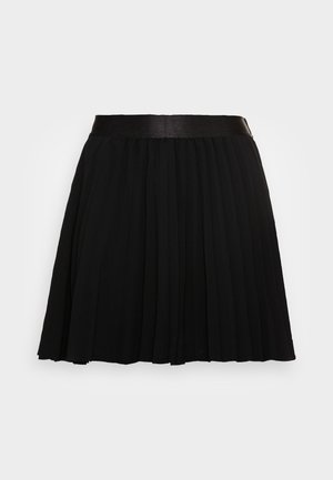 Jupe plissée noire avec une ceinture lisse, longueur genou, présentée sur un fond uni gris clair.
