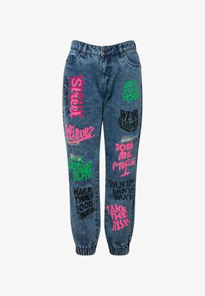 Pantalones jogger de mezclilla con varios estampados gráficos de colores en rosa, verde y negro. Cuenta con puños elásticos y detalles desgastados.